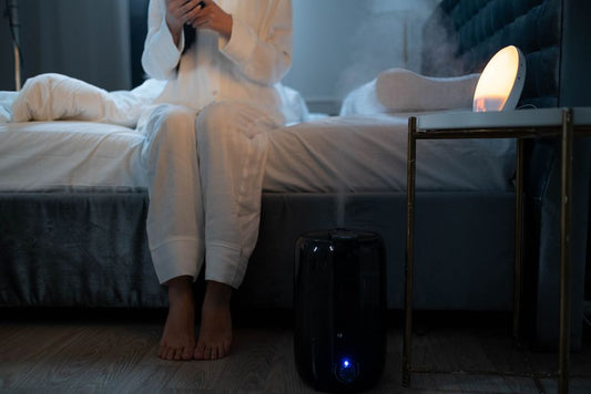 Un humidificateur diffuse une fine brume dans une chambre à l'ambiance tamisée le soir.