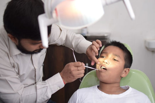Un chirurgien-dentiste examine la bouche d'un enfant dans un cabinet lumineux