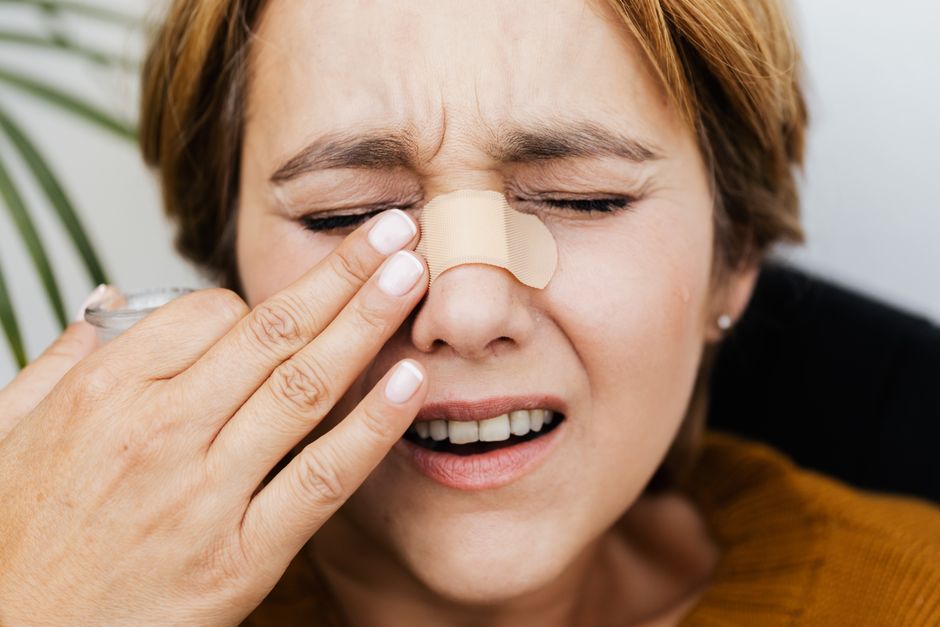 Femme se touchant le nez, signe d'irritation ou de gêne nasale