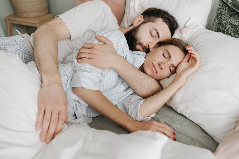 Un couple allongé dans son lit, détendu, à l'approche de la Saint-Valentin