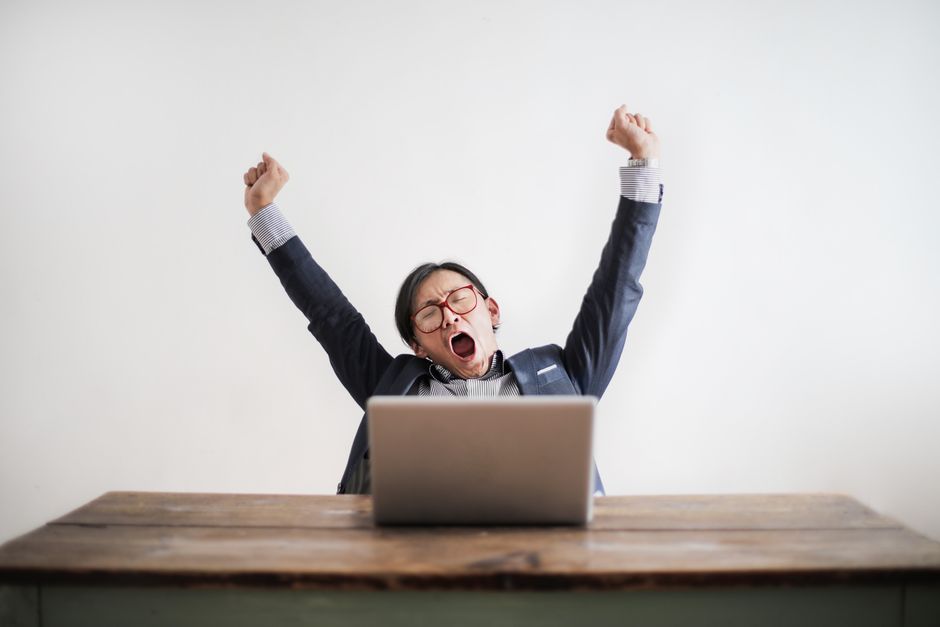 Homme fatigué qui bâille devant son ordinateur au bureau
