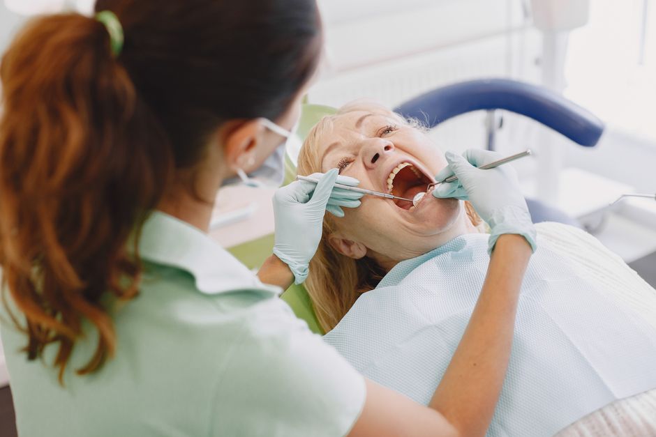 Dentiste examinant la bouche d'une patiente lors d'une consultation