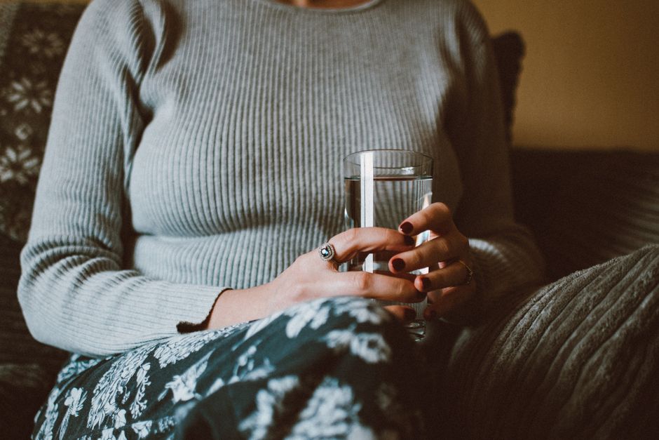 Femme buvant un verre d'eau pour soulager une sensation de bouche sèche