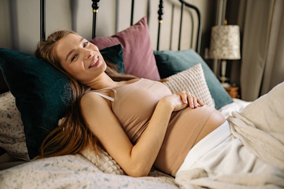 Femme enceinte allongée et détendue dans son lit