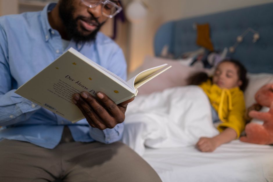 Un père lit une histoire du soir à sa fille avant qu'elle s'endorme