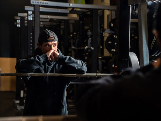 Pratiquant qui reprend son souffle après une série intense en salle de sport.