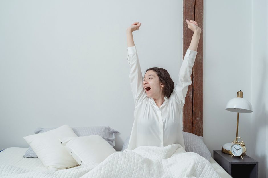 Femme qui s'étire au réveil après une nuit passée à respirer la bouche ouverte