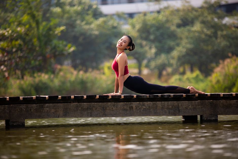 Femme en posture de yoga en extérieur, concentrée sur sa respiration