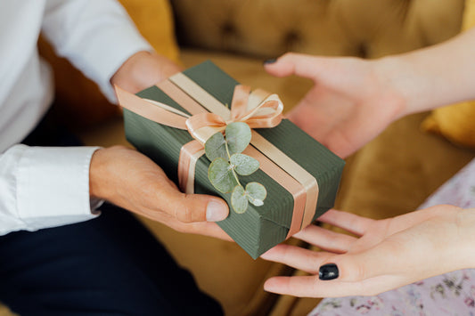 Deux personnes échangent un cadeau d'anniversaire emballé avec un ruban